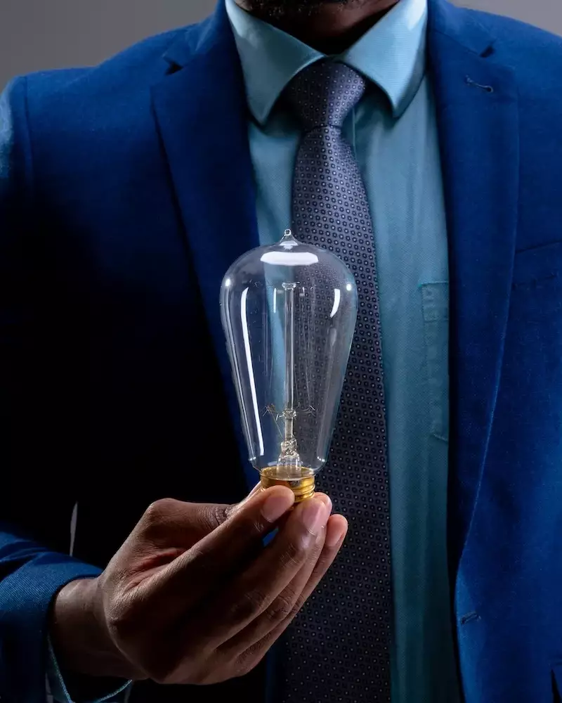 businessman holding light bulb